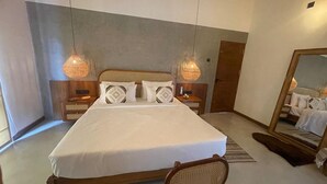 A modern bedroom with a large bed, two bedside tables, a wooden chair, a mirror, and two hanging lamps. - Alo Kai Villa (Weligama)
