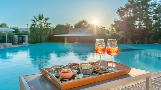 A tray with food and drinks by a pool with a sunset in the background. - Hotel Sabhè (Gallipoli)