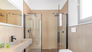 A modern bathroom with a glass-enclosed shower, a white sink, and a toilet. - Hotel Sabhè (Gallipoli)