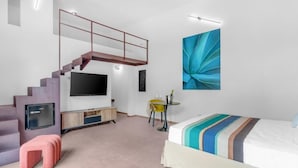 A modern bedroom with a staircase, a flat-screen TV, a bed with striped bedding, and a large abstract painting. - Hotel Sabhè (Gallipoli)