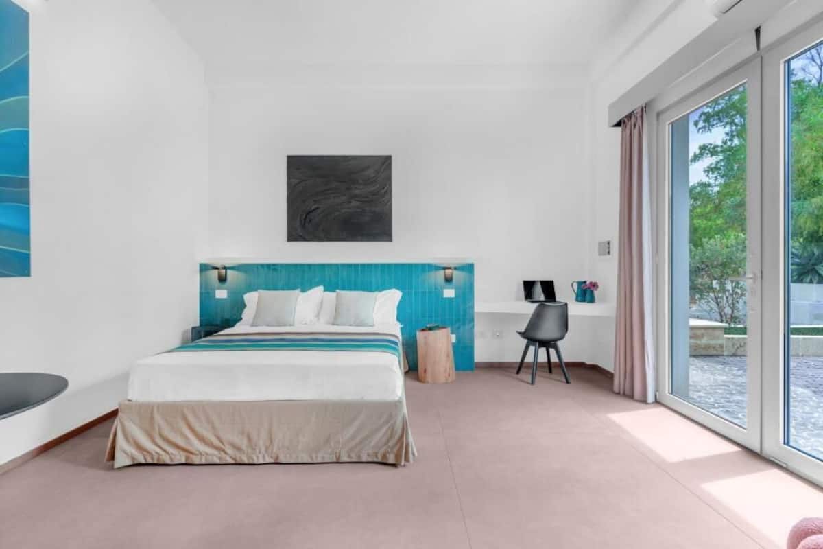 Un dormitorio moderno con una cama grande, un escritorio y vistas al exterior.