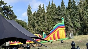 Puisto, jossa on suuri puhallettava liukumäki ja shakkilauta.