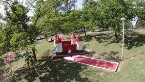 A castle-themed playground with a slide and climbing structures. - ZEcamping 3* animé piscine locatif TV clim 28m2 4 pers (Nailloux)