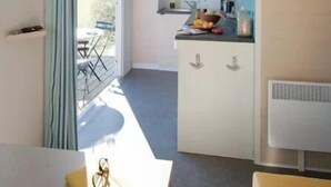 Una cucina compatta con angolo ristoro, un tavolino e una sedia.