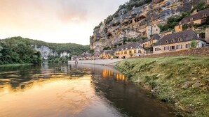 Une ville riveraine dont les bâtiments sont construits à flanc de falaise.