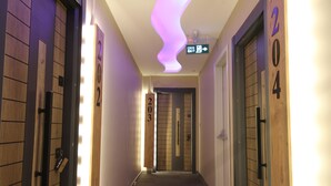 A hotel hallway with doors numbered 202, 203, and 204, and an exit sign above door 203. - ROYAL İNN BORNOVA (İzmir)