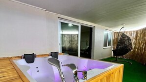 A wooden hot tub with three faucets, a wooden deck, and a green artificial turf floor. - ROYAL İNN BORNOVA (İzmir)