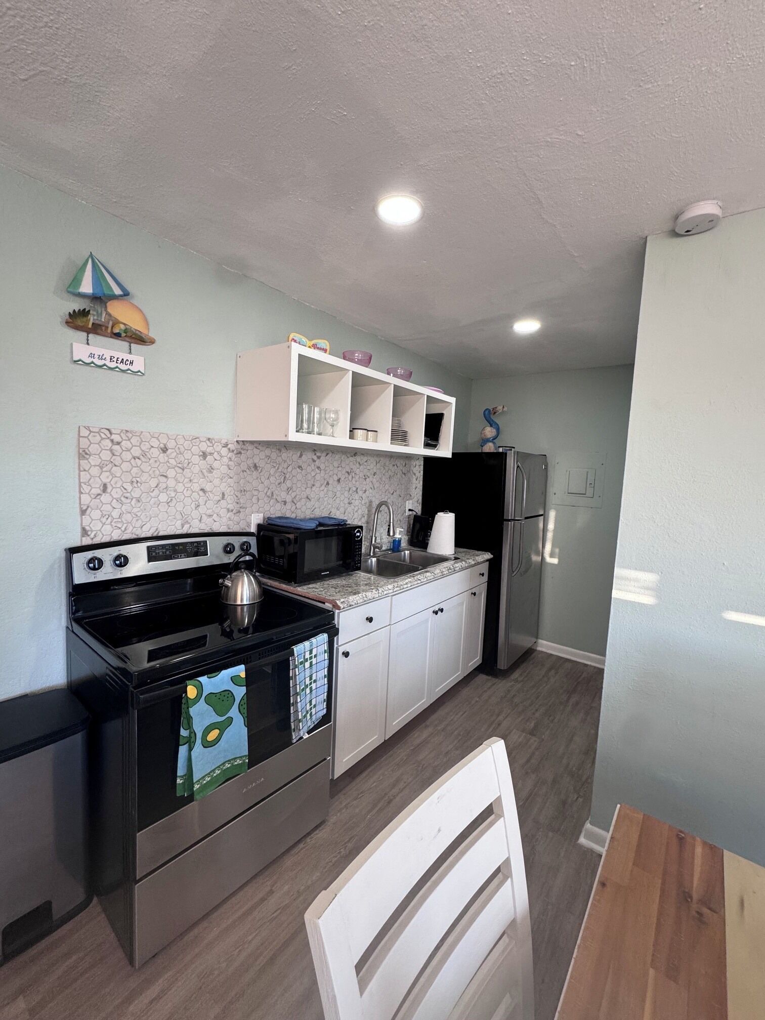 A compact kitchen with a stove, microwave, and refrigerator.
