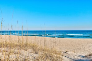 Een strand met heldere lucht en golven.