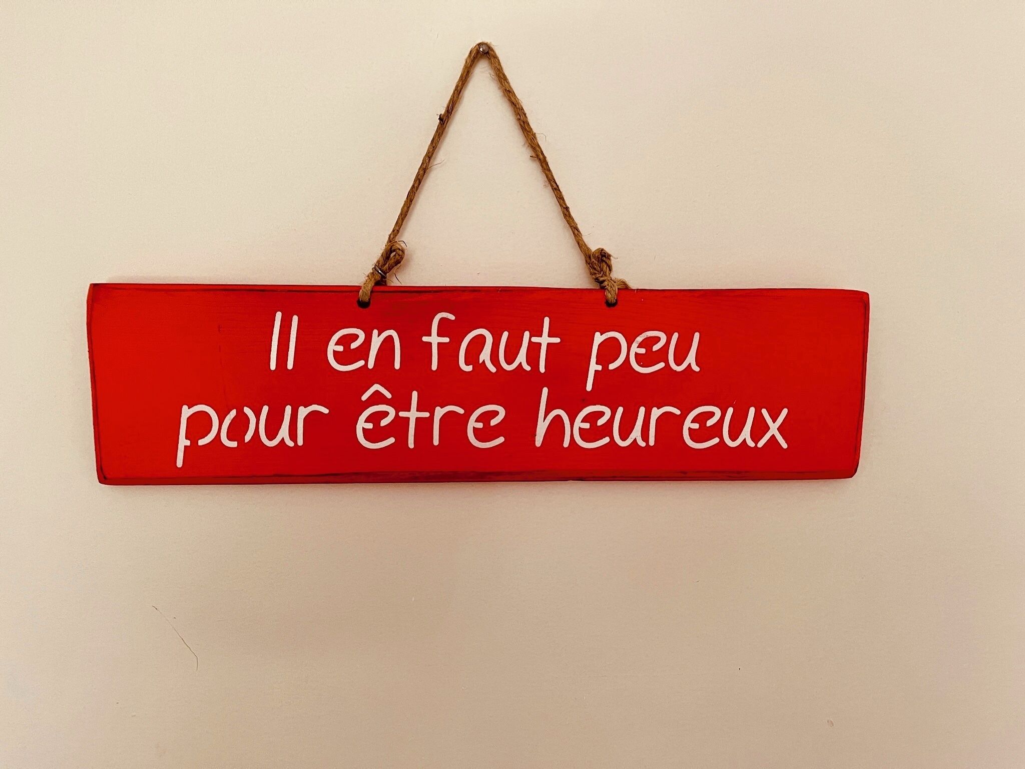 Um sinal vermelho com texto branco pendurado na parede.