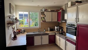 A kitchen with a window, cabinets, a sink, and various kitchen appliances. - Family home in Belle-Ile-En-Mer (Le Palais)
