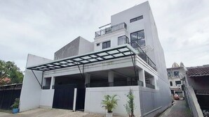 Une maison moderne à deux étages, dotée d’un garage fermé et d’un balcon.