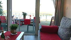 Una habitación con sofá, una mesa y vistas al exterior.