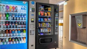 Máquina expendedora con un dispensador de agua a la izquierda y uno de snacks a la derecha, ambos con varias opciones.