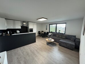 Eine moderne Wohnung mit Küche, Essbereich und Wohnzimmer.