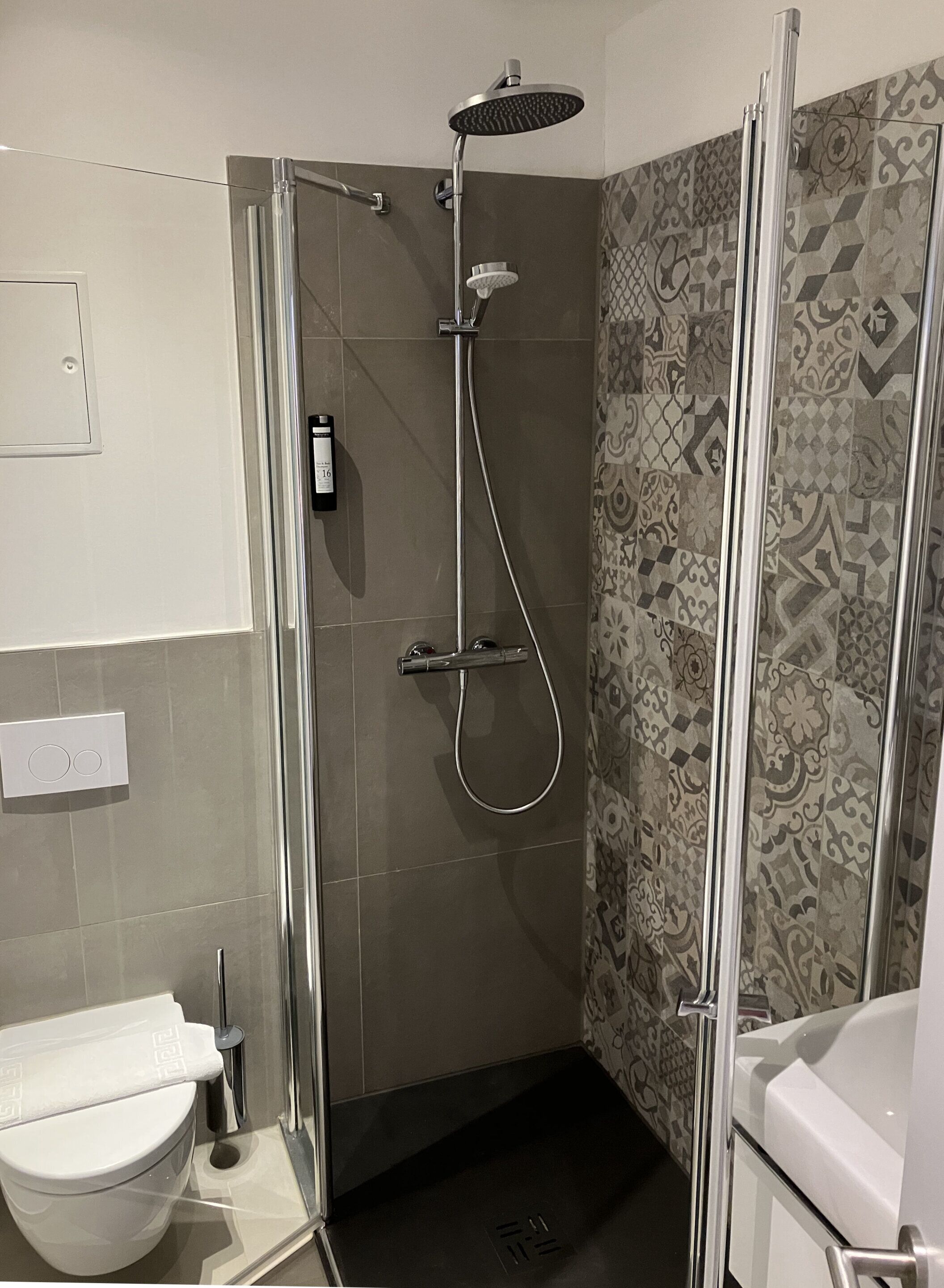 Un baño moderno con ducha acristalada, inodoro y bañera.