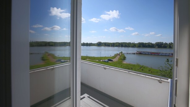 Un balcon avec vue sur un lac et un bateau.