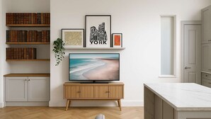 Una sala de estar moderna con un televisor de pantalla plana, estanterías de madera y un diseño minimalista.