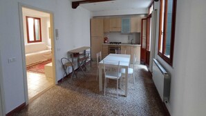 A compact kitchen with a dining area, a small table, and chairs. There is a window providing natural light. - Figher 795 ( near the Rialto Bridge ) (Venezia)