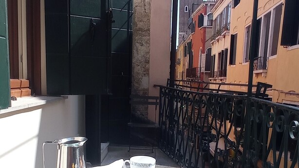 A balcony with a table set for breakfast, including croissants, coffee, and a teapot. - Figher 795 ( near the Rialto Bridge ) (Venezia)