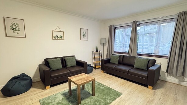 A living room with two sofas, a coffee table, a bean bag, and a floor lamp. - Modern 3BDR Family Home Near Welsh Harp Hendon (Greater London)