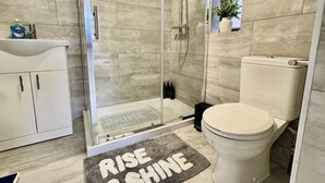 A bathroom with a glass-enclosed shower, a toilet, a sink, and a cabinet. - Modern 3BDR Family Home Near Welsh Harp Hendon (Greater London)