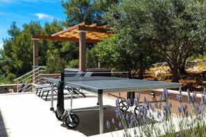 An outdoor ping pong table with a pergola structure, surrounded by trees and outdoor seating. - Holiday home Villa Franciska (Blato)
