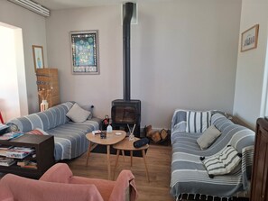 A cozy living room with two sofas, a fireplace, a bookshelf, and a decorative wall piece. - 10-person house with pool in the center of La Tremblade, 5 minutes from the ocean (La tremblade)