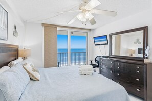 A bedroom with a bed, a dresser, a television, and a balcony with a view of the ocean. - SC1-802 | Gulf-Front 3BR Condo • Direct Balcony Views (Indian Shores)
