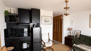 A compact living space with a kitchenette, a dining area, and a seating area. - Studio 180° sea view - Terrace - Sunset (Calais)