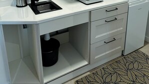 A compact kitchenette with a white countertop, a black sink, a microwave, and a stove. - Kirana Rural Apartment in Urdaibai (Bermeo)