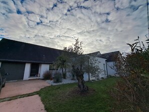 A residential property with a white exterior, a dark roof, and a well-maintained lawn. - Family home within walking distance of the beach! (Sarzeau)