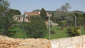 A stone wall and a chain-link fence in the foreground. - Finca Can Jan (Llucmajor)