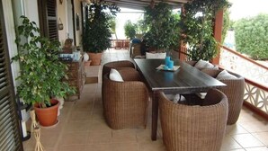 An outdoor patio with wicker furniture, a table, and potted plants. - Finca Can Jan (Llucmajor)