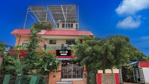 A hotel with a red roof, solar panels, a gated entrance, and a signboard. - Hotel O Jodhpur Cantt Railway Junction (Jodhpur)