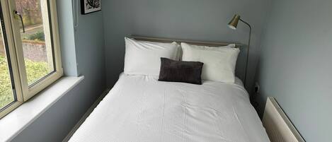 Tabla de planchar con plancha, internet y ropa de cama