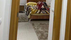 Un dormitorio con cama, mesita de noche y tocador.