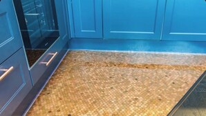 Una cocina con armarios azules y piso de mosaicos.
