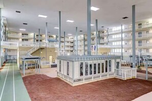 Un hotel de varios pisos con balcones, un atrium central y una pequeña área exterior con techo.