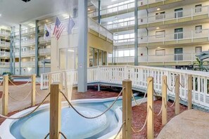 Un atrio interior de varios niveles con una piscina central, balcones y banderas estadounidenses.