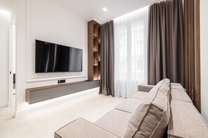 Una sala de estar moderna con un televisor de pantalla plana, un sofá modular y un mueble empotrado para entretenimiento.