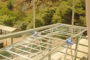 A balcony with a metal drying rack and a view of a hillside with trees. - Fully equipped apartment for 6 - Relax and enjoy Viña del Mar (Viña del Mar)