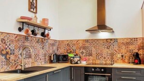A kitchen with a patterned backsplash, a sink, a stove, and a microwave. - Diesel's Desirable Den - Luxury rural 2 bed cottage, peaceful walks and stays UK (Maidstone)