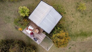 Vista aérea de una casa con terraza amurallada, jacuzzi y zona de patio con mobiliario.