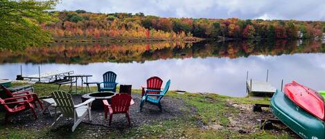 A lakeside setting with outdoor seating and a dock.