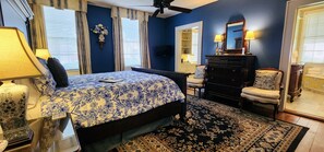 A bedroom with a bed, dresser, chair, and a large mirror. - Andrew Morris House Bed and Breakfast (Natchitoches)