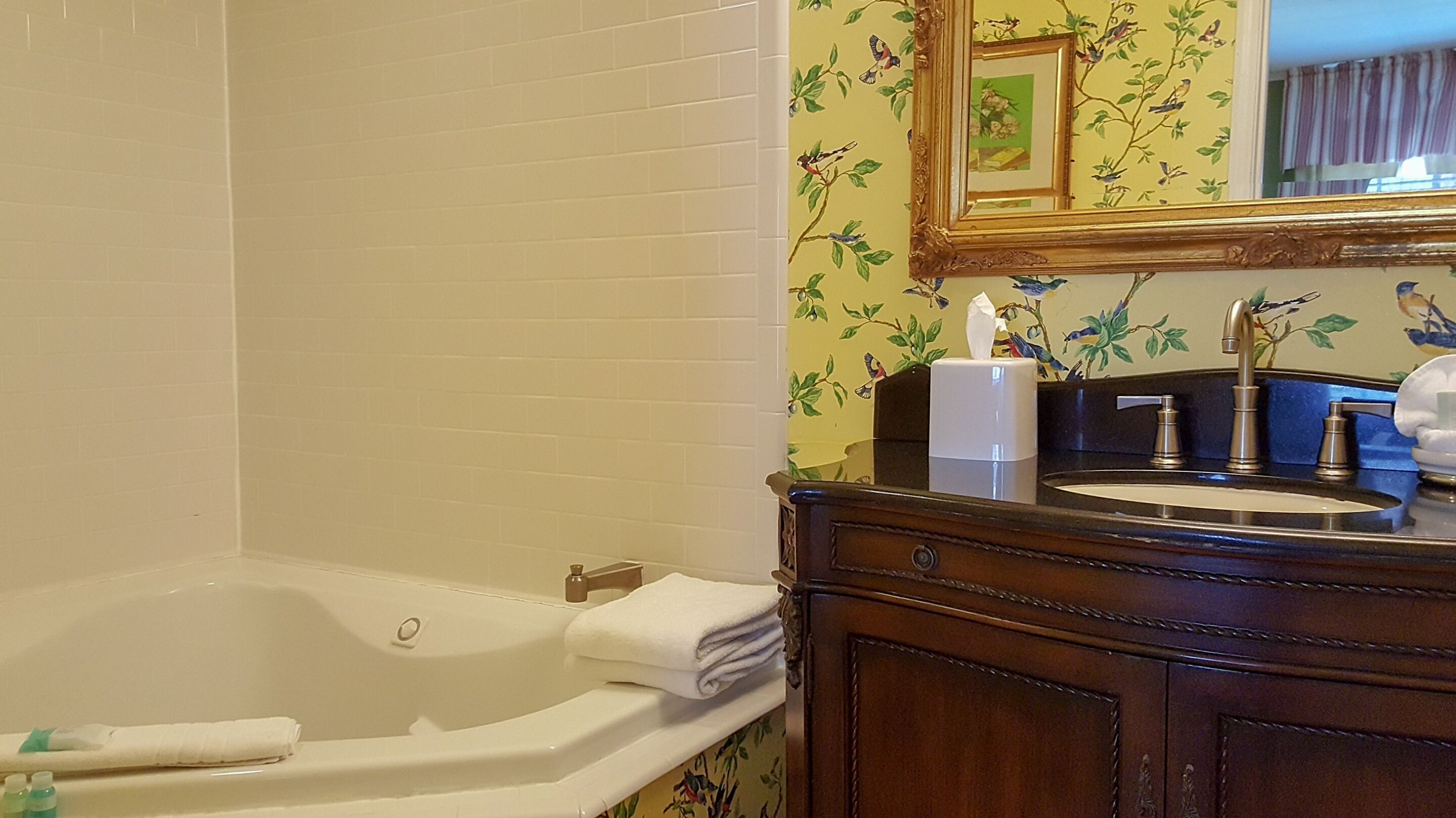 A bathroom with a bathtub, a sink, and a mirror.
