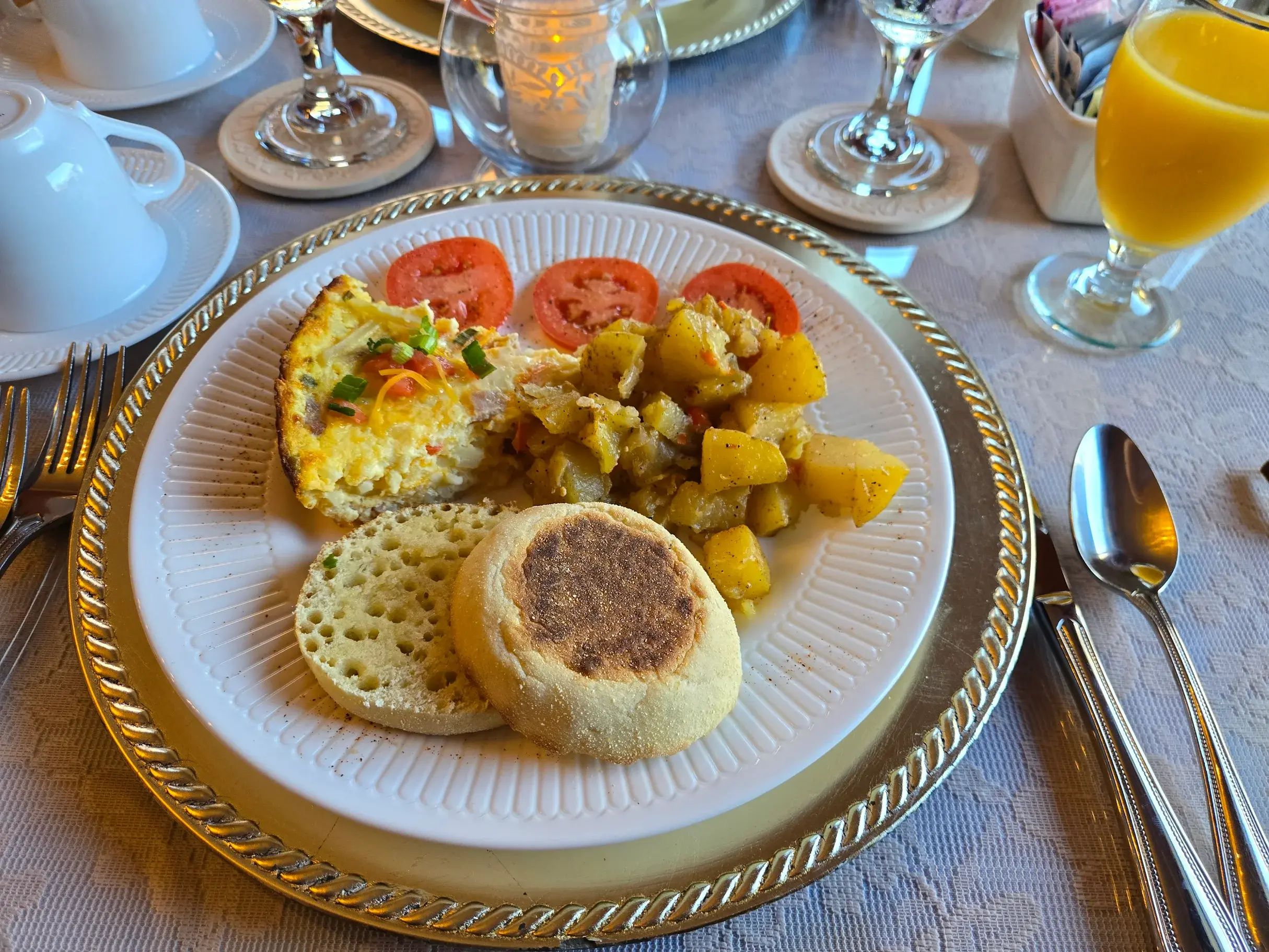 A breakfast plate with eggs, potatoes, tomatoes, and toast.
