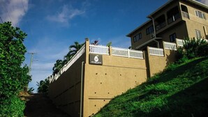 A building with a white fence, a sign with 'GP' and 'Golden Pearl,' and a sloped roof.