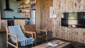 A modern kitchen with wooden cabinetry, a built-in microwave, and a stainless steel refrigerator.